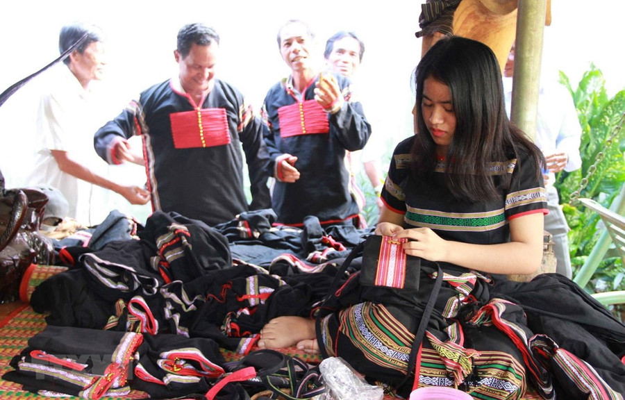 Hiện nay, xã viên Hợp tác xã Dệt thổ cẩm Tơng Bông, tỉnh Đắk Nông, đều biết dệt may thành thạo các sản phẩm như y phục nam nữ, túi xách, cà vạt, khăn trải bàn, gối tựa lưng, áo dài, quần áo trẻ em. (Ảnh: TTXVN phát)