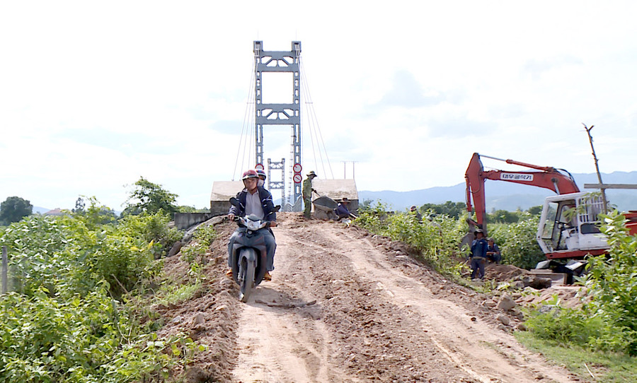 Sửa chữa, khắc phục nền và mặt đường để đảm bảo giao thông thuận lợi tại vị trí đường dẫn 2 đầu cầu treo dân sinh H’Jú. Ảnh: Lê Hòa