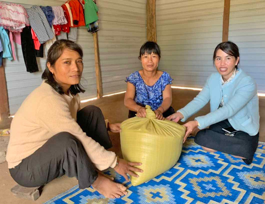 Chị Ksor H' Duyr (ở giữa, buôn Choanh, xã Uar, huyện Krông Pa) vui mừng nhận gạo từ mô hình Hũ gạo tình thương.Ảnh.Vũ Chi