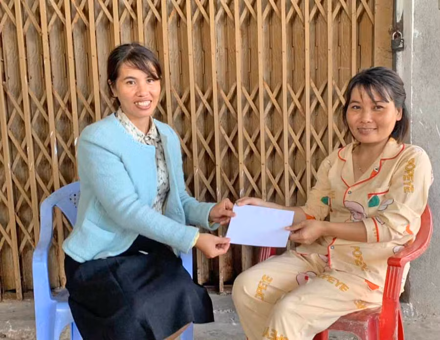 Chị Phạm Thị Nguyên (bìa phải, thôn An Bình, xã Uar, huyện Krông Pa) nhận vốn vay từ tổ tiết kiệm để kịp thời khám-chữa bệnh. Ảnh: Vũ Chi