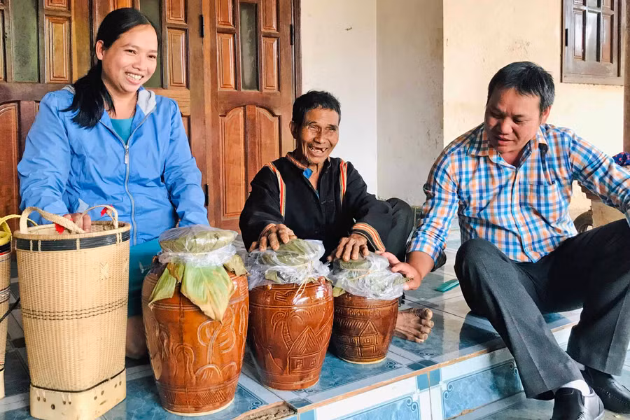  Già Pich (bìa phải; làng Xóa, xã Chư Đang Ya, huyện Chư Păh) phấn khởi chuẩn bị ghè rượu cần đón khách du lịch. Ảnh: Trần Dung
