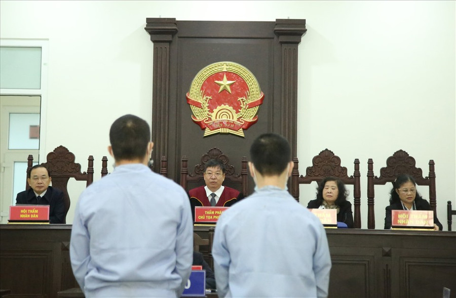 Hai bị cáo (áo xanh, đứng) tại phiên toà xét xử hôm nay do cáo buộc đâm tài xế xe ôm công nghệ để cướp. Ảnh: V.Dũng. Hai bị cáo (áo xanh, đứng) tại phiên toà xét xử hôm nay do cáo buộc đâm tài xế xe ôm công nghệ để cướp. Ảnh: V.Dũng.