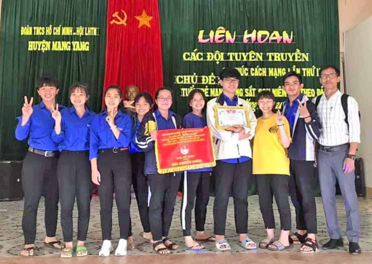 Thầy Nay A Yôn (bìa phải) cùng các em học sinh Trường THPT Trần Hưng Đạo tham gia Liên hoan các đội tuyên truyền ca khúc cách mạng do Huyện Đoàn Mang Yang tổ chức. Ảnh: Thủy Bình