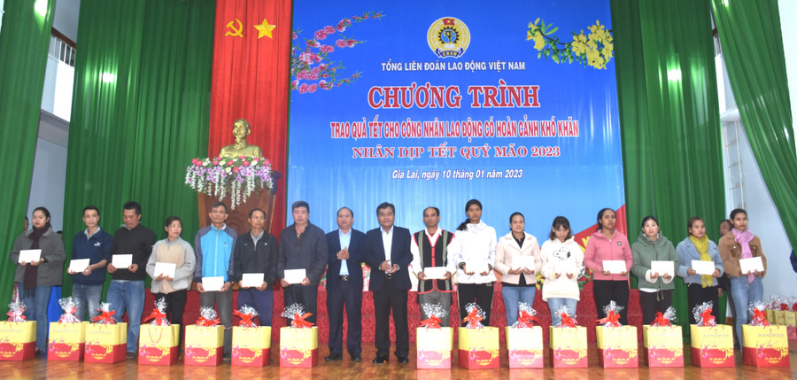 Các đồng chí Hồ Văn Niên (thứ 9 từ phải qua)- Ủy viên Ban Chấp hành Trung ương Đảng, Bí thư Tỉnh ủy, Chủ tịch HĐND tỉnh và Rah Lan Chung (thứ 8 từ trái qua)-Phó Bí thư Tỉnh ủy trao quà cho công nhân, lao động có hoàn cảnh khó khăn. Ảnh. Đinh Yến