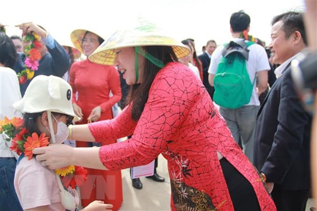 Bà Nguyễn Thị Lệ Thanh, Giám đốc Sở Du lịch Khánh Hòa, tặng vòng hoa chào đón khách du lịch Hàn Quốc đến với Khánh Hòa trong ngày đầu Năm mới 2023. Ảnh: Phan Sáu/TTXVN