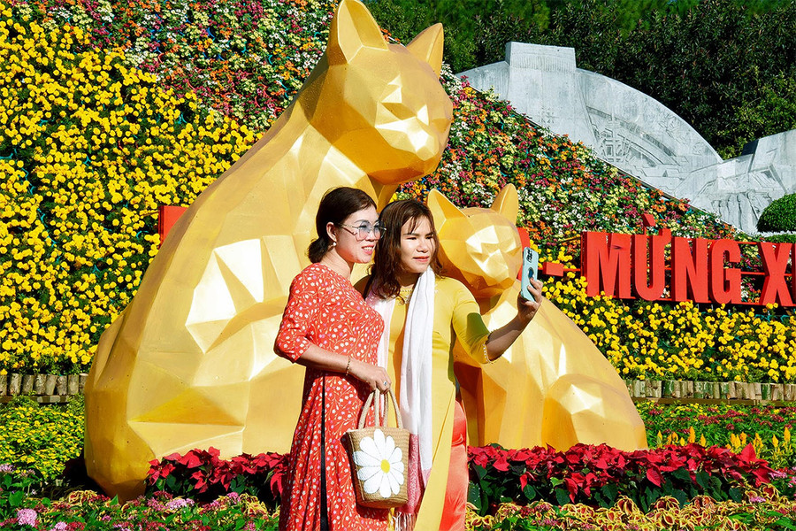 Khách tham quan thích thú lưu lại những khoảnh khắc đẹp bên gia đình tại đường hoa Quảng trường Đại Đoàn Kết.