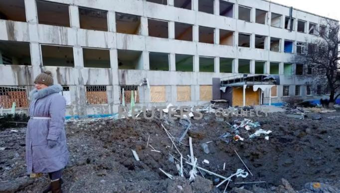 Người phụ nữ đứng cạnh đống đổ nát sau cuộc tấn công bằng tên lửa xảy ra trong đêm 8-1. Ảnh: Reuters