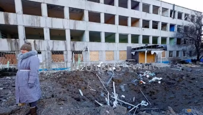 Người phụ nữ đứng cạnh đống đổ nát sau cuộc tấn công bằng tên lửa xảy ra trong đêm 8-1. Ảnh: Reuters