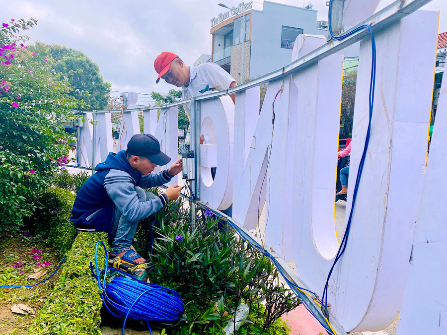 Lắp đặt hệ thống điện trang trí tại khu vực vòng xoay Đỗ Trạc-Hoàng Hoa Thám-Hai Bà Trưng (phường Tây Sơn). Ảnh: Mộc Trà