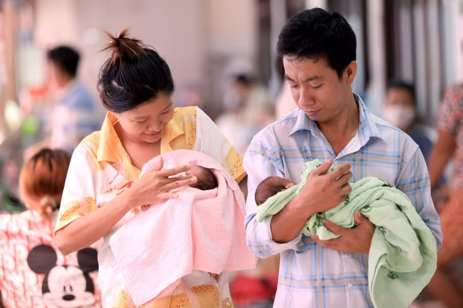 Vợ chồng anh Phạm Nhân Trung chăm con. Ảnh: Ngọc Dương