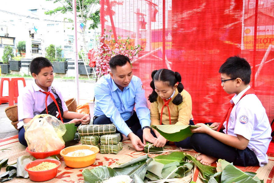 Gia Lai: 2.000 thiếu nhi tham gia ngày hội "Thiếu nhi Việt Nam-Học tập tốt, rèn luyện chăm" ảnh 3 Anh Lê Anh Quân (thứ 2 từ trái qua)-Phó Chủ tịch Hội đồng Đội Trung ương, Chủ tịch Hội đồng Huấn luyện Trung ương cùng các em thiếu nhi trải nghiệm hoạt động gói bánh chưng. Ảnh: Đức Thụy
