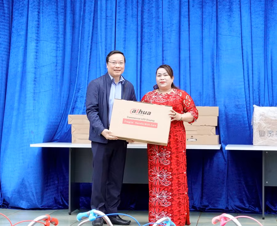 Cô Nguyễn Thị Thảo (bìa phải)-Hiệu trưởng Trường Tiểu học và THCS Anh Hùng Đôn đón nhận phần quà là 8 bộ máy vi tính từ Chủ tịch UBND tỉnh Trương Hải Long trao tặng. Ảnh: Mộc Trà