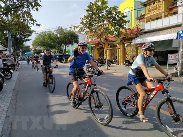 Du khách nước ngoài đi xe đạp trải nghiệm tại thành phố Bến Tre. Ảnh: Huỳnh Phúc Hậu/TTXVN