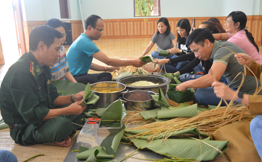cán bộ, công chức viên chức 2 đơn vị cùng tham gia gói bánh chưng, bánh tét với cán bộ, chiến sĩ Đồn Biên phòng Ia Pnôn. Ảnh: Anh Huy