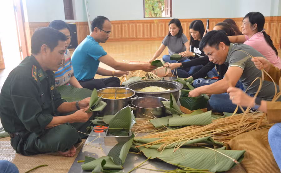 cán bộ, công chức viên chức 2 đơn vị cùng tham gia gói bánh chưng, bánh tét với cán bộ, chiến sĩ Đồn Biên phòng Ia Pnôn. Ảnh: Anh Huy