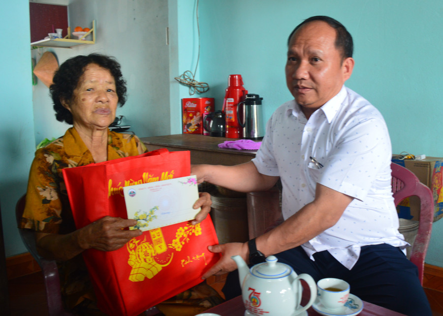 Phó Bí thư Tỉnh ủy Rah Lan Chung tặng quà cho bà Nguyễn Thị Em. Ảnh: Anh Huy