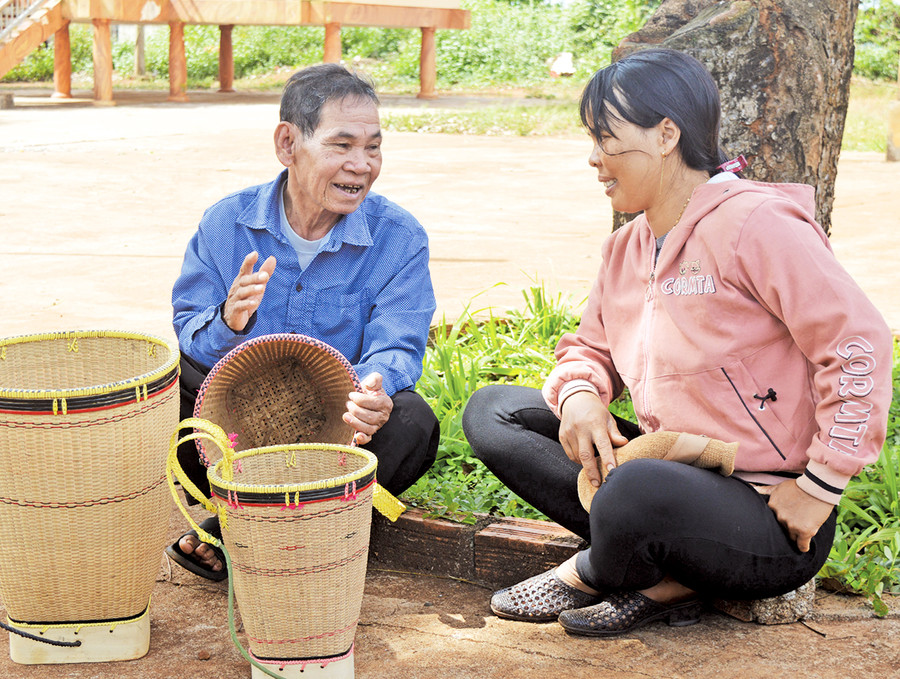 Già làng Rơ Mah Chun (bìa trái) vận động người dân chăm lo phát triển kinh tế. Ảnh: Anh Huy