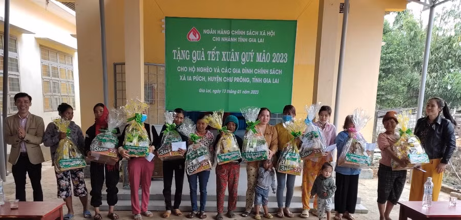 Ông Đinh Văn Nghĩa (ngoài cùng bên trái) trao tặng quà Tết của Ngân hàng Chính sách Xã hội cho bà con xã Ia Púch. Ảnh: Sơn Ca