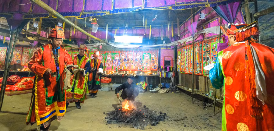 Nghi thức đốt giấy với hàm ý xua đuổi ma quỷ. Tranh thờ người Dao Đỏ được treo khắp gian phòng làm lễ