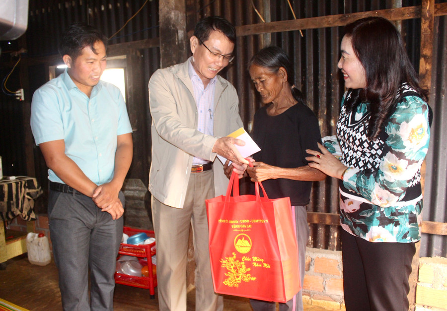 Bí thư Thành ủy Pleiku Trịnh Duy Thuân (thứ 2 từ trái qua) tặng quà Tết cho gia đình bà Rơ Châm Láp (thứ 2 từ phải qua, làng Sát Tâu, xã Ia Pếch, huyện Ia Grai). Ảnh: Phan Làithư