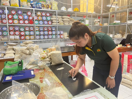 Kỹ sư tại Nhà máy chế biến gạo Thoại Sơn đang kiểm tra kích thước không đồng đều của hạt gạo để đi phân tích Kỹ sư tại Nhà máy chế biến gạo Thoại Sơn đang kiểm tra kích thước không đồng đều của hạt gạo để đi phân tích