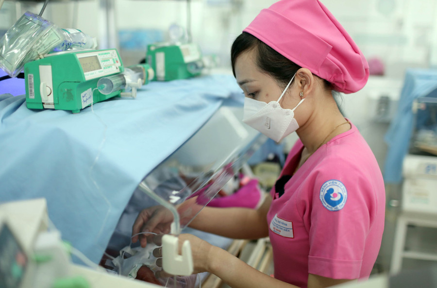 NHS Trần Thị Thu Hiền chăm sóc 1 bé trong lồng ấp.