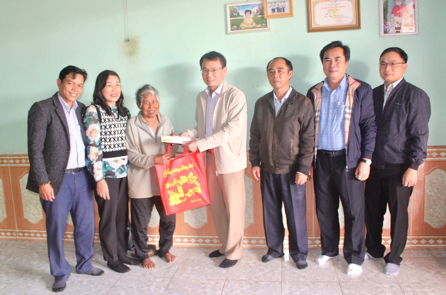 Bí thư Thành ủy Pleiku Trịnh Duy Thuân (ở giữa) tặng quà Tết cho gia đình ông Puih Alum (làng Blang 3, xã Ia Dêr, huyện Ia Grai). Ảnh: Phan Lài