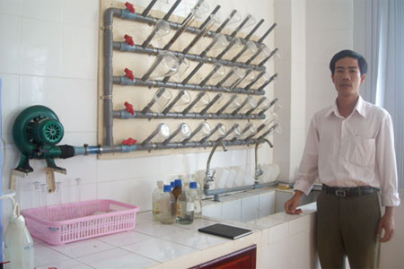 Người thiết kế, chế tạo giá đỡ sấy khô dụng cụ thí nghiệm ảnh 1 Anh Huệ bên công trình sáng tạo của mình. Ảnh: Hương Trà