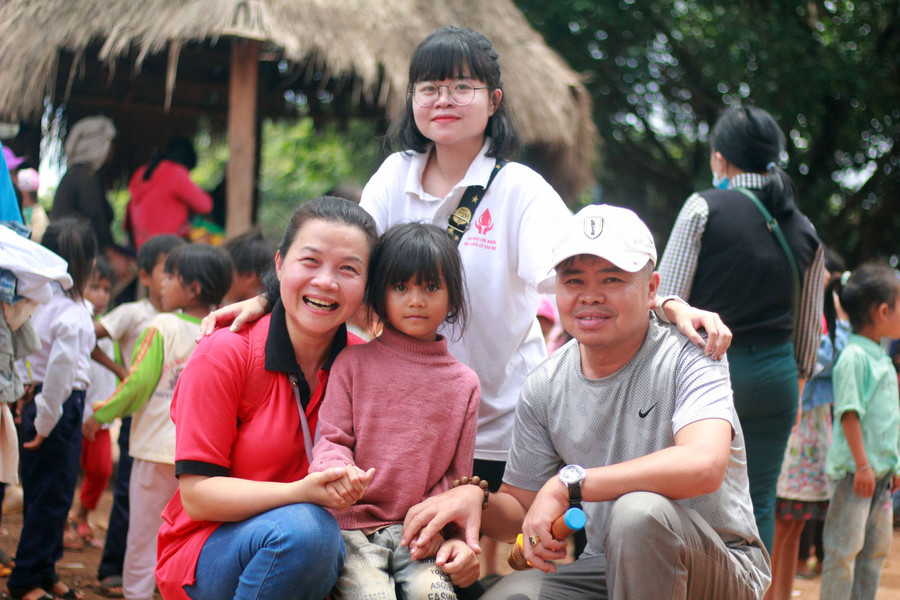 Vợ chồng anh Nguyễn Tấn Minh chụp hình cùng em nhỏ xã Kon Chiêng (huyện Mang Yang). Ảnh: Phan Lài