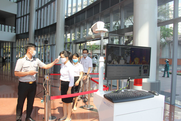 Đo thân nhiệt và hạn chế tối đa người đến làm việc tại Trung tâm Hành chính, trừ trường hợp phải giải quyết công việc cấp bách - Ảnh: T.TRUNG