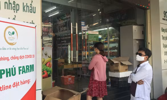 Người dân xếp hàng mua thực phẩm tại một cửa hàng ở Đà Nẵng trong mùa dịch - Ảnh: TRƯỜNG TRUNG