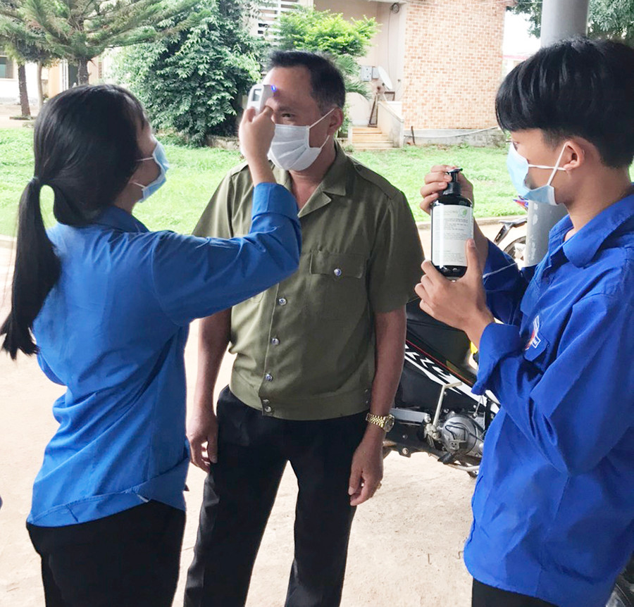 Đoàn viên, thanh niên tiến hành đo thân nhiệt cho người dân khi đến trụ sở UBND thị trấn đăng ký làm việc. Ảnh: Hà Phương Đoàn viên, thanh niên tiến hành đo thân nhiệt cho người dân khi đến trụ sở UBND thị trấn đăng ký làm việc. Ảnh: Hà Phương