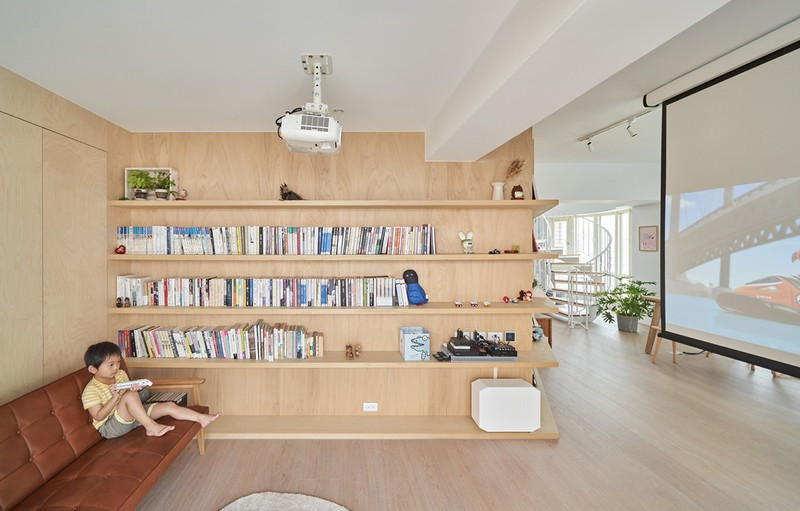 Thay vào đó là màn hình chiếu cùng kệ sách bố trí dọc theo tường.