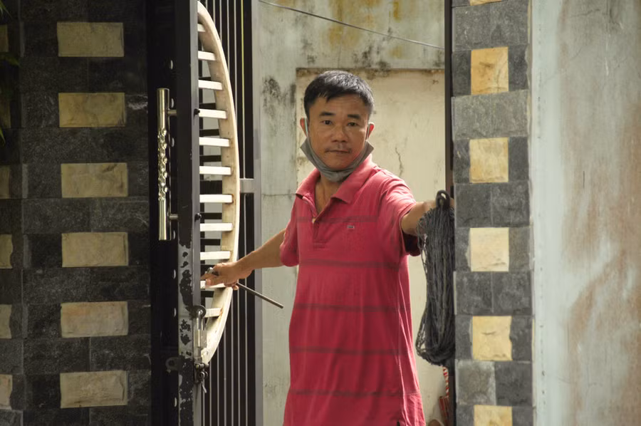 Vừa mở hé ra để đổ bao rác, người đàn ông trong khu dân cư Lưu Minh này đã vội khép chặt cánh cửa để ngăn người khác vào nhà, tránh lây lan dịch - Ảnh: B.D