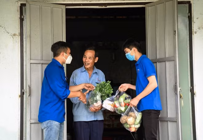 Nhiều người dân vui vẻ khi tận tay nhận những phần quà từ các bạn trẻ. ẢNH: NAM THỊNH