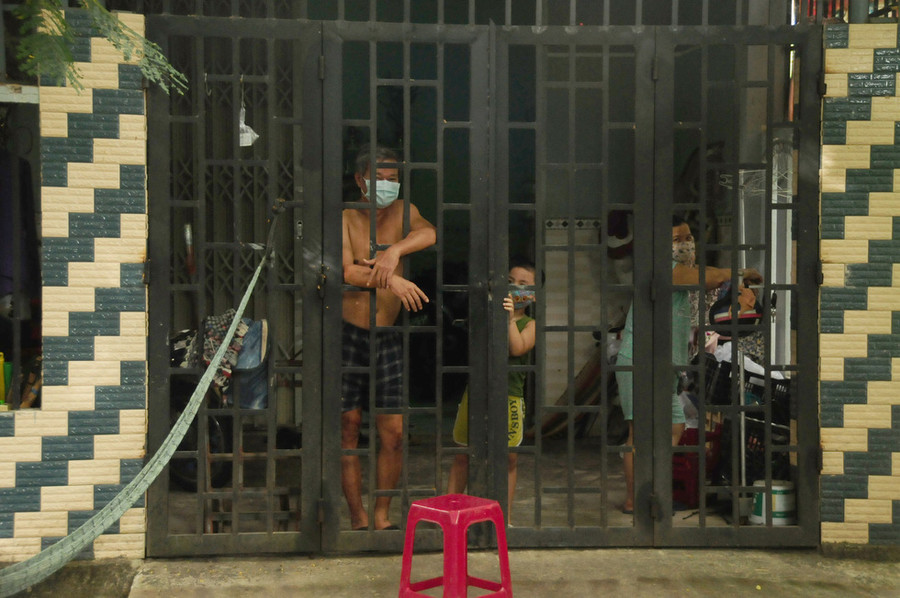 Cả người lớn lẫn trẻ con đều chỉ biết tựa cửa nhìn ra, chờ dịch qua đi trong bình an cho gia đình, xóm làng - Ảnh: B.D