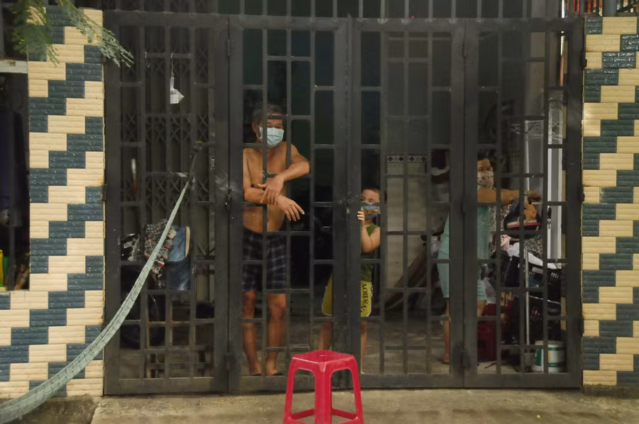 Cả người lớn lẫn trẻ con đều chỉ biết tựa cửa nhìn ra, chờ dịch qua đi trong bình an cho gia đình, xóm làng - Ảnh: B.D