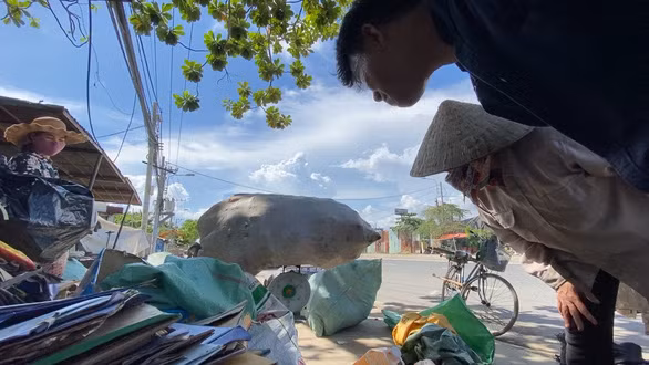 PV Thành Nhơn và chị Dương cân bán ve chai sau một ngày đi nhặt - Ảnh TỰ TRUNG