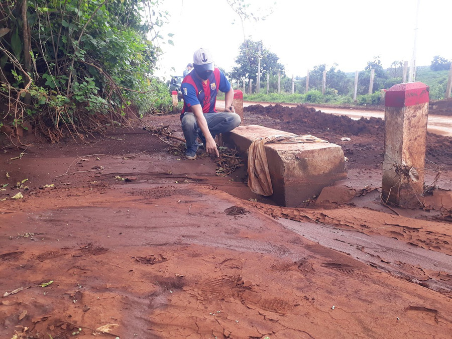 Bùn đất lấp kín cống bê tông mới xây khiến nước chảy tràn ra mặt đường. Ảnh: Nguyễn Tú 