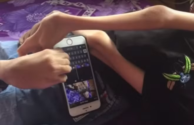 Tâm tự dựng video clip của mình trên điện thoại bằng chân