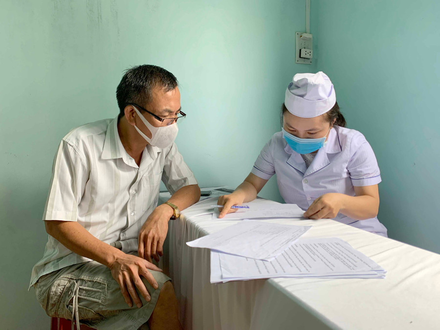 Nhân viên y tế phường Phù Đổng (TP. Pleiku) hướng dẫn người dân khai báo y tế. Ảnh: Như Nguyện 