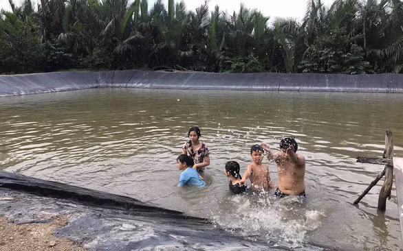 Đám trẻ về quê nội ở Long An thích thú với trò tắm ao - Ảnh: K.ANH