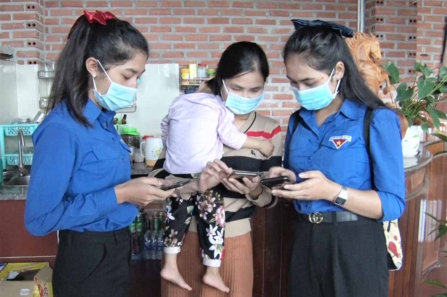  Các bạn ĐVTN đang hướng dẫn cho người dân cài đặt ứng dụng Bluezone. Ảnh: H.Đ.T