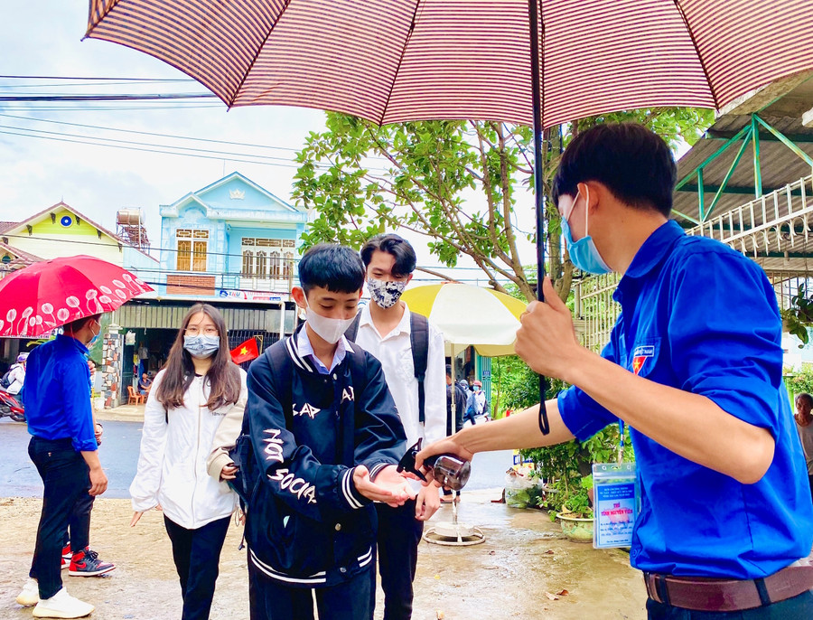 Xịt nước rửa tay sát khuẩn cho thí sinh trước khi vào điểm thi. Ảnh: Hồng Thi Xịt nước rửa tay sát khuẩn cho thí sinh trước khi vào điểm thi. Ảnh: Hồng Thi