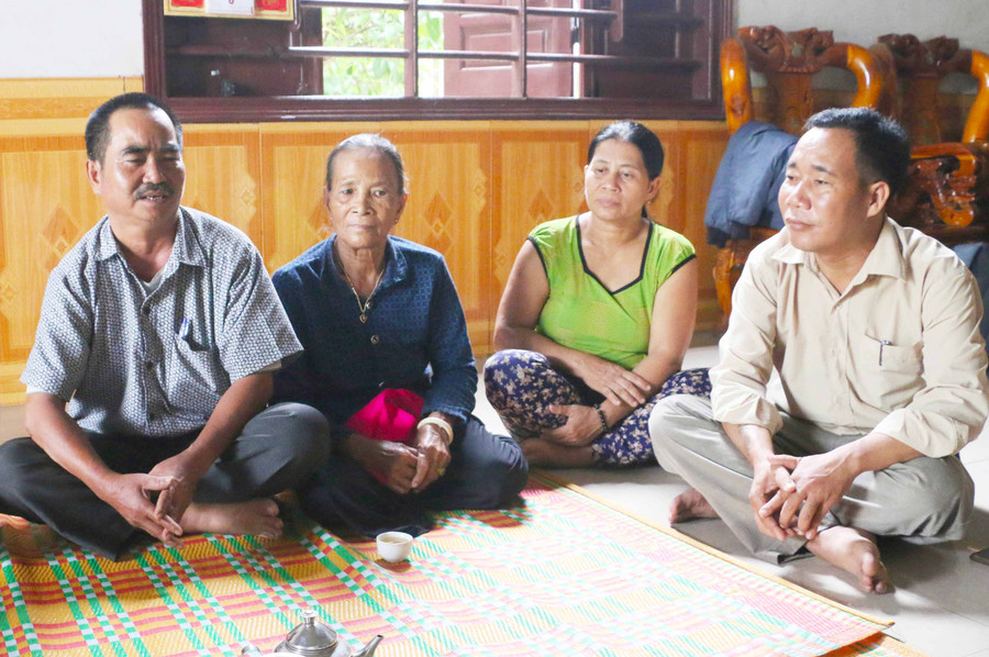 Ông Kpă Quang (bìa phải) tới từng hộ dân tuyên truyền, vận động đẩy lùi hủ tục. Ảnh: Trần Dung 