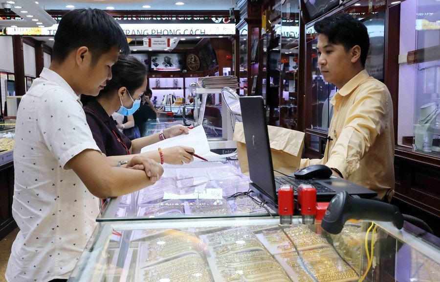  Khách mua bán vàng tại Công ty Kinh doanh vàng bạc Bảo Tín Minh Châu. (Ảnh: Trần Việt - TTXVN)