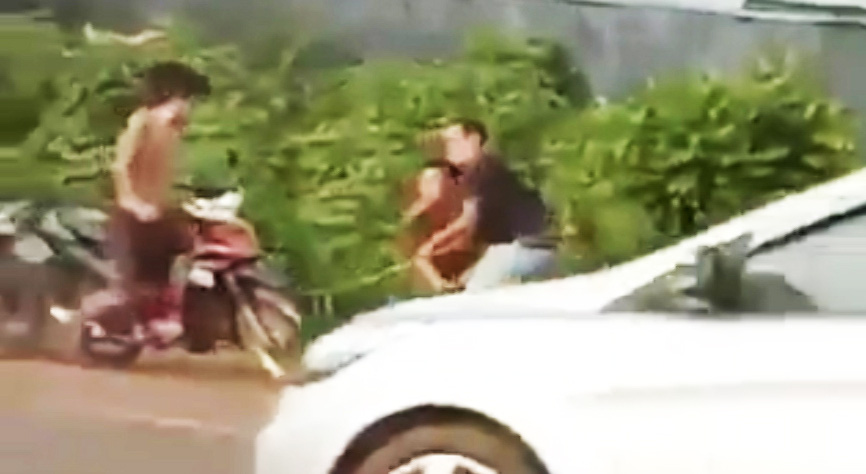 Một người mặc cảnh phục dùng gậy đánh một người đàn ông (ảnh cắt từ clip). Một người mặc cảnh phục dùng gậy đánh một người đàn ông (ảnh cắt từ clip).