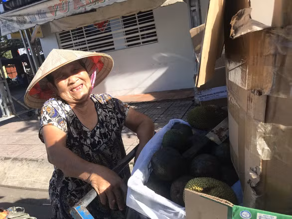 Bà cụ Nguyễn Thị Ảo nhặt mít từ thùng rác - Ảnh: T.NHƠN