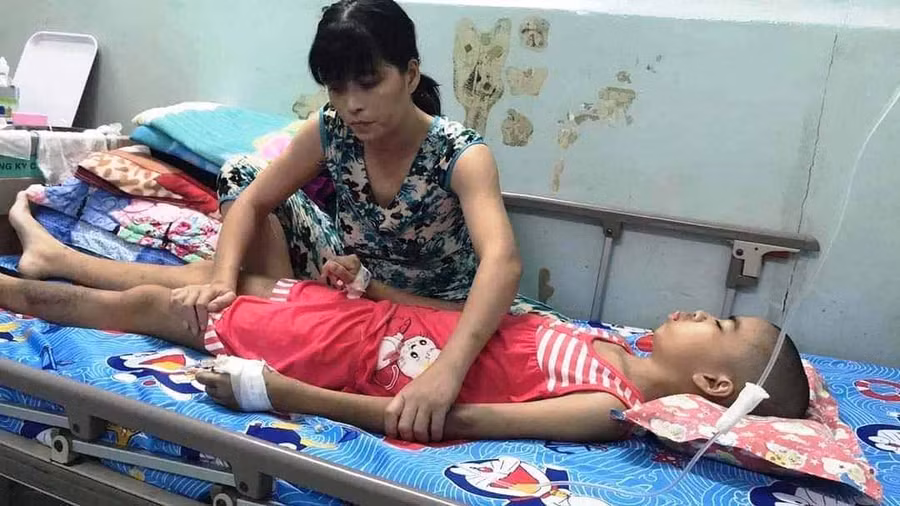 Chị Nguyễn Thị Lan Thanh chăm sóc con gái Quỳnh Anh tại bệnh viện. Ảnh: Nhật Hào 