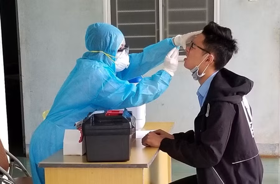 Lấy mẫu xét nghiệm cho một học sinh lớp 12 tham gia Kỳ thi tốt nghiệp THPT năm 2020. Ảnh: Như Nguyện